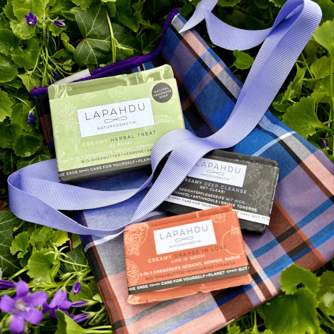3 Naturseifen von Lapahdu Naturkosmetik im blau-lila kariertem geschenkbeutel mit edler lila schleife, schickes geschenk für jeden anlass